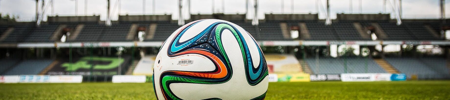 multicolored soccer ball on green field